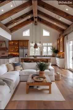 a living room filled with lots of furniture and wooden beams on the ceiling above it