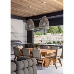 an open kitchen and dining room area with wood ceiling lights hanging from the ceiling, along with modern furniture