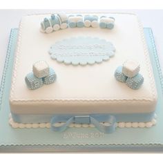 a blue and white cake decorated with baby's first birthday items on top of it