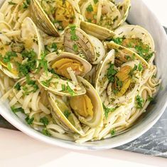 a white bowl filled with clams and pasta