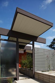 an outdoor covered patio with potted plants on the side