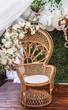 a wicker chair sitting on top of a wooden floor next to balloons and flowers