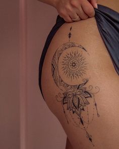 a woman with a tattoo on her thigh holding onto a piece of cloth in front of her back