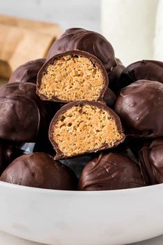 a white bowl filled with chocolate covered peanut butter balls