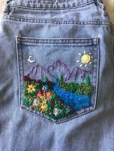 the back pocket of a pair of jeans with embroidered flowers and trees on it,