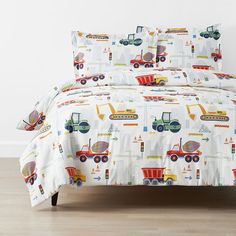 a bed with construction themed sheets and pillows