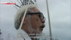 an older man with glasses and a white beard is standing in front of power lines