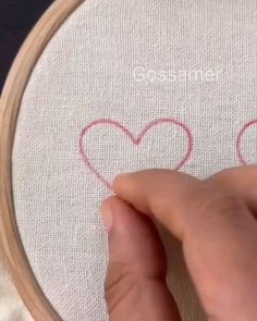 someone is stitching two hearts on a piece of fabric