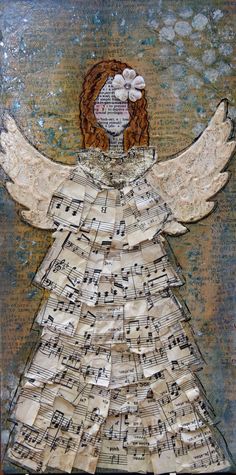 an angel made out of old sheet music notes with white flowers on it's wings