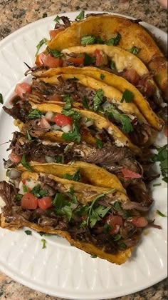 a white plate topped with tacos covered in toppings