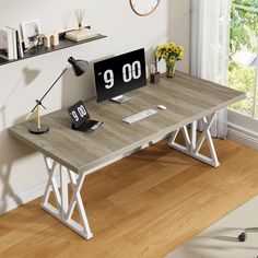 a computer desk with a clock on it in front of a window and wooden floor