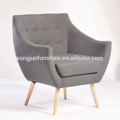 grey fabric chair with wooden legs and buttoned upholstered back, on white background