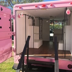 the inside of a pink and white truck with its door open to reveal it's storage area