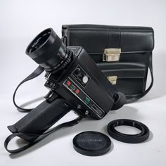 an old camera is sitting next to a black bag