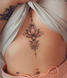 a woman's stomach with a tattoo on her back and an arrow in the middle