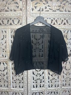 This breathtakingly beautiful black sheer beaded shawl is a unique addition to any wardrobe. Crafted with exquisite details like delicate beading, this cropped shawl adds a timeless touch of elegance to your look. Perfect for all occasions, you'll love the classic sophistication of this piece. Beaded Shawl, Shawl, Beading, Boutique, Wardrobe, Black