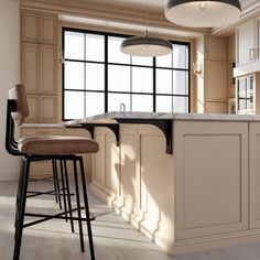 a kitchen with an island and bar stools next to the counter top in front of a large window