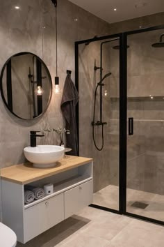 a bathroom with a sink, mirror and shower stall in it's center area