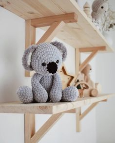 a crocheted koala bear sitting on top of a shelf