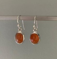 Sterling silver Carnelian oval earrings, deep orange colour, 925 sterling silver, birthstone of August.Carnelian is a stabilising stone, restores vitality and motivation, stimulates creativity, gives courage, promotes positive life choices, helps you trust in your perceptions and in yourself.A gift for her for any occasion.Your earrings will be presented in our funky drawstring bags. Orange And Silver Outfit, Silver And Stone Jewelry, Funky Silver Earrings, Stud Earrings Silver, Silver Carnelian Earrings, Earrings Boho, Colourful Earrings, Cute Silver Earrings, Boho Silver Earrings