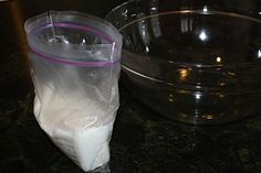 a clear plastic bag sitting on top of a counter next to a bowl