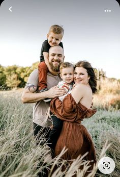 a man, woman and child are posing for a photo in the tall grass with their arms around each other