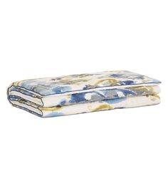 the blue and yellow floral print sheets are folded on top of each other, with one sheet