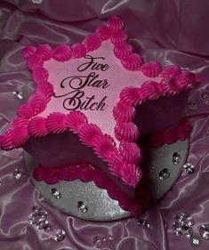 there is a cake that has been decorated with pink icing and stars on it