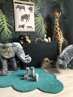 an elephant, giraffe and other stuffed animals in a child's room