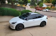 a white car parked in front of a house