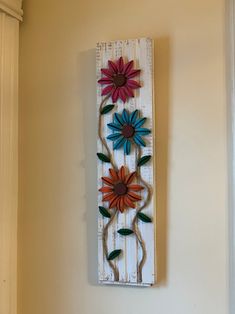 a wooden wall hanging with flowers on it