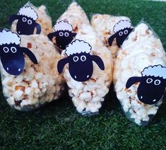 four sheep made out of popcorn sitting on the grass