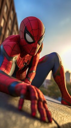 spider - man is sitting on the ground in front of a building