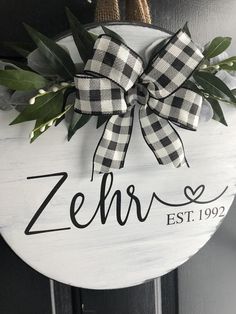 a sign that says zehr est 1909 hanging on a door with leaves and ribbon