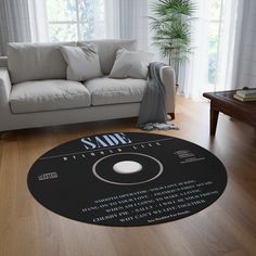 a living room with a white couch and large round rug on the floor in front of a window