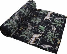 a roll of black fabric with giraffes and palm trees on the ground