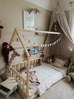 a child's bedroom with a bed and stuffed animals on the floor, including a giraffe