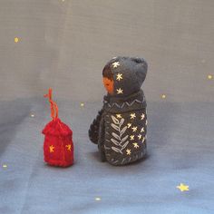 a small stuffed animal sitting next to a red bag with stars on it's side