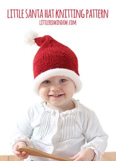 a baby wearing a santa hat playing with a wooden spoon