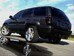 a black suv is parked on the side of the road