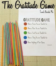 a group of colored straws sitting next to a paper with the words, the gratitude game