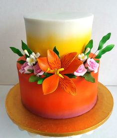 an orange and yellow cake with flowers on top