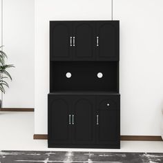 a black cabinet sitting in the corner of a room next to a white chair and potted plant