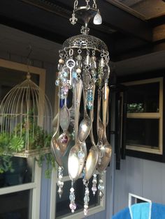 a chandelier with spoons hanging from it's sides and glass beads