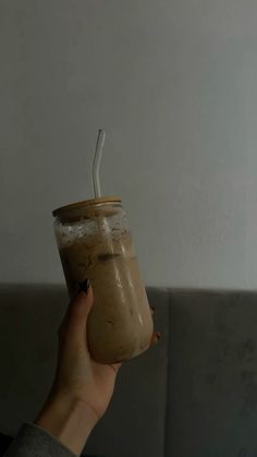 a person holding a glass with a straw in it