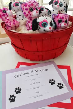 a basket filled with stuffed animals sitting on top of a table next to a certificate