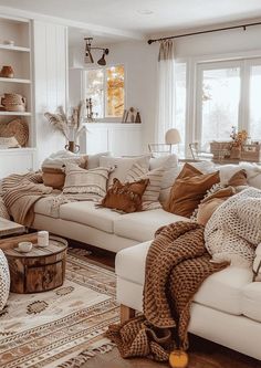 a living room filled with white furniture and lots of pillows on top of it's couches