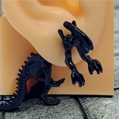 a small black lizard figurine sitting on top of a piece of plastic