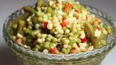 a glass bowl filled with corn and vegetables