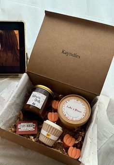 an open box containing jams and cookies on a table